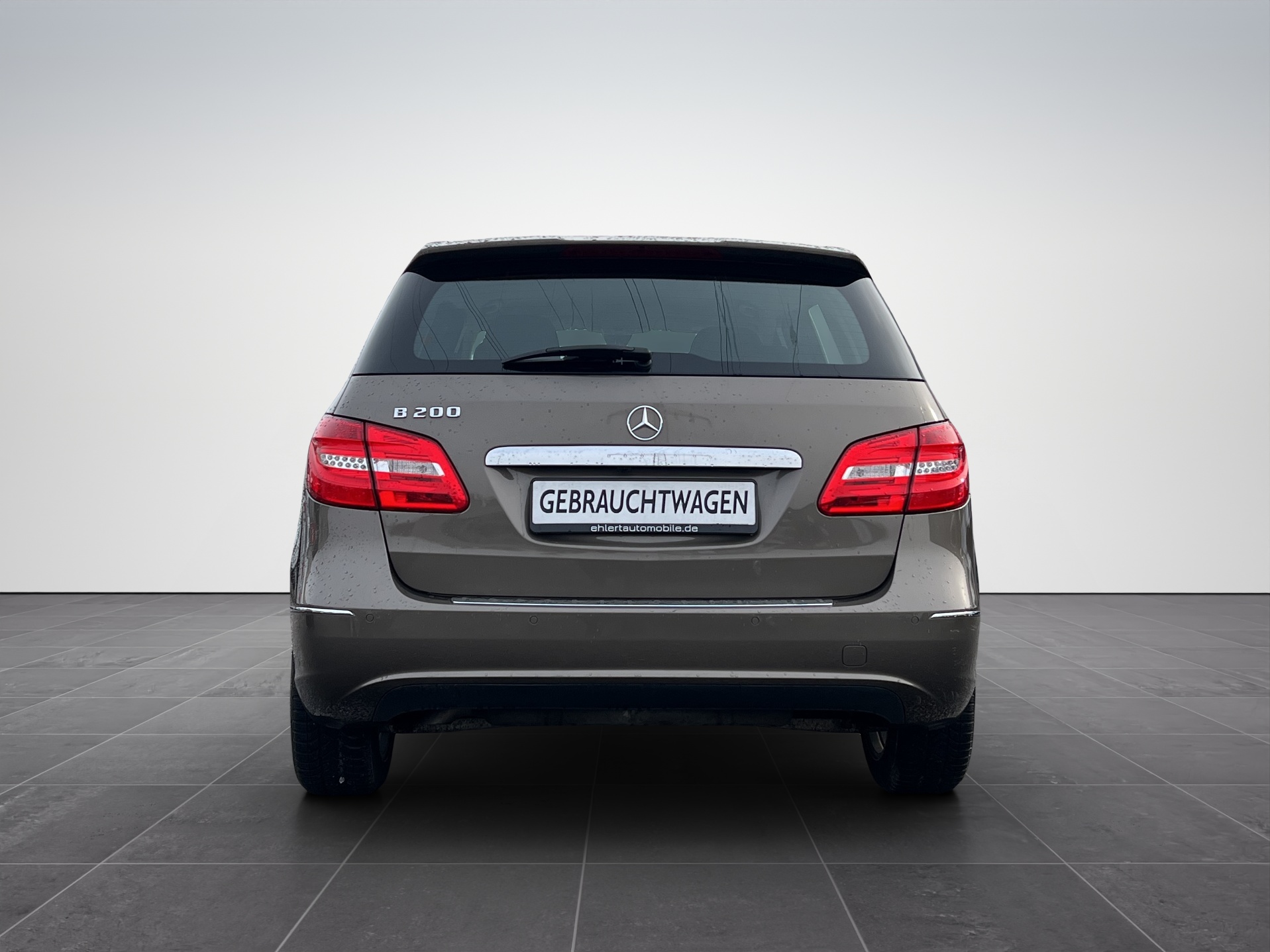 Heckansicht eines grauen Mercedes-Benz mit minimalistischem Hintergrund.