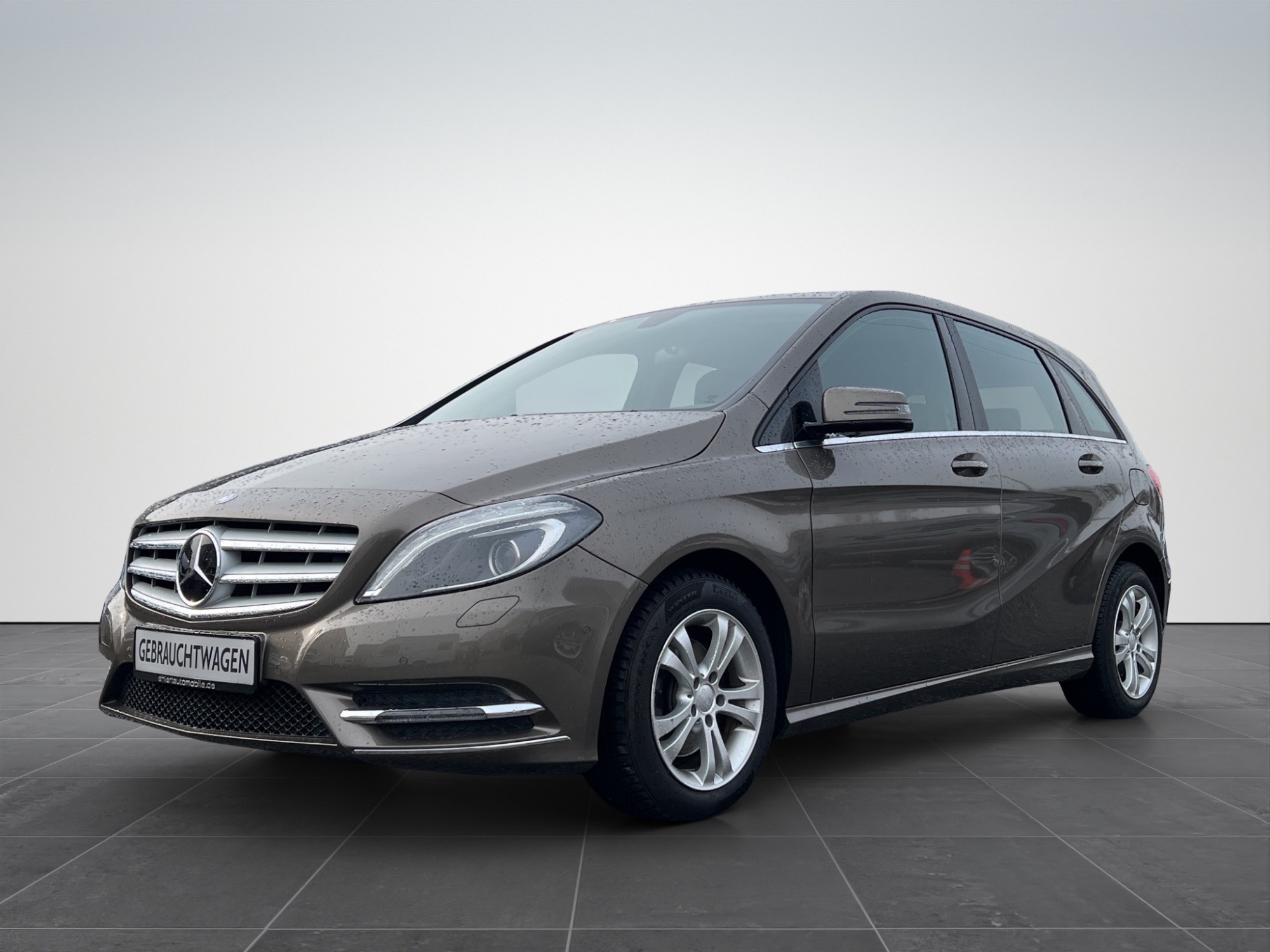 Brauner Mercedes-Benz Kompaktwagen mit silbernen Felgen, seitlich aufgenommen.