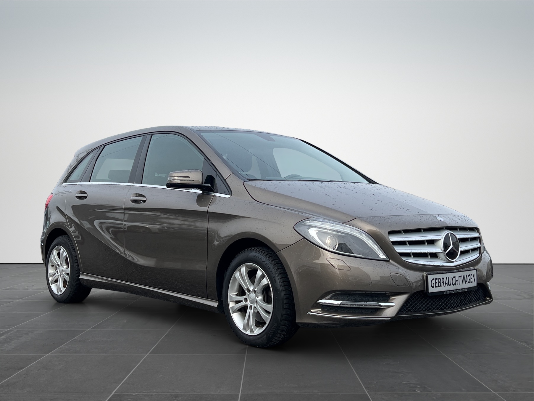 Brauner Kompaktwagen der Marke Mercedes-Benz, seitliche Ansicht auf neutralem Hintergrund.