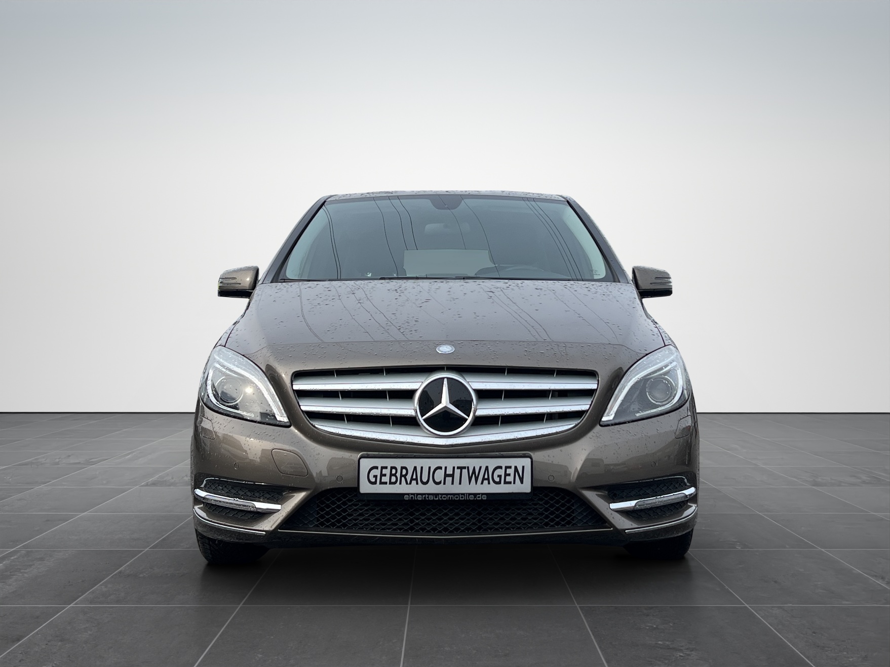 Grauer Mercedes-Benz Van mit markanter Frontansicht auf grauem Hintergrund.